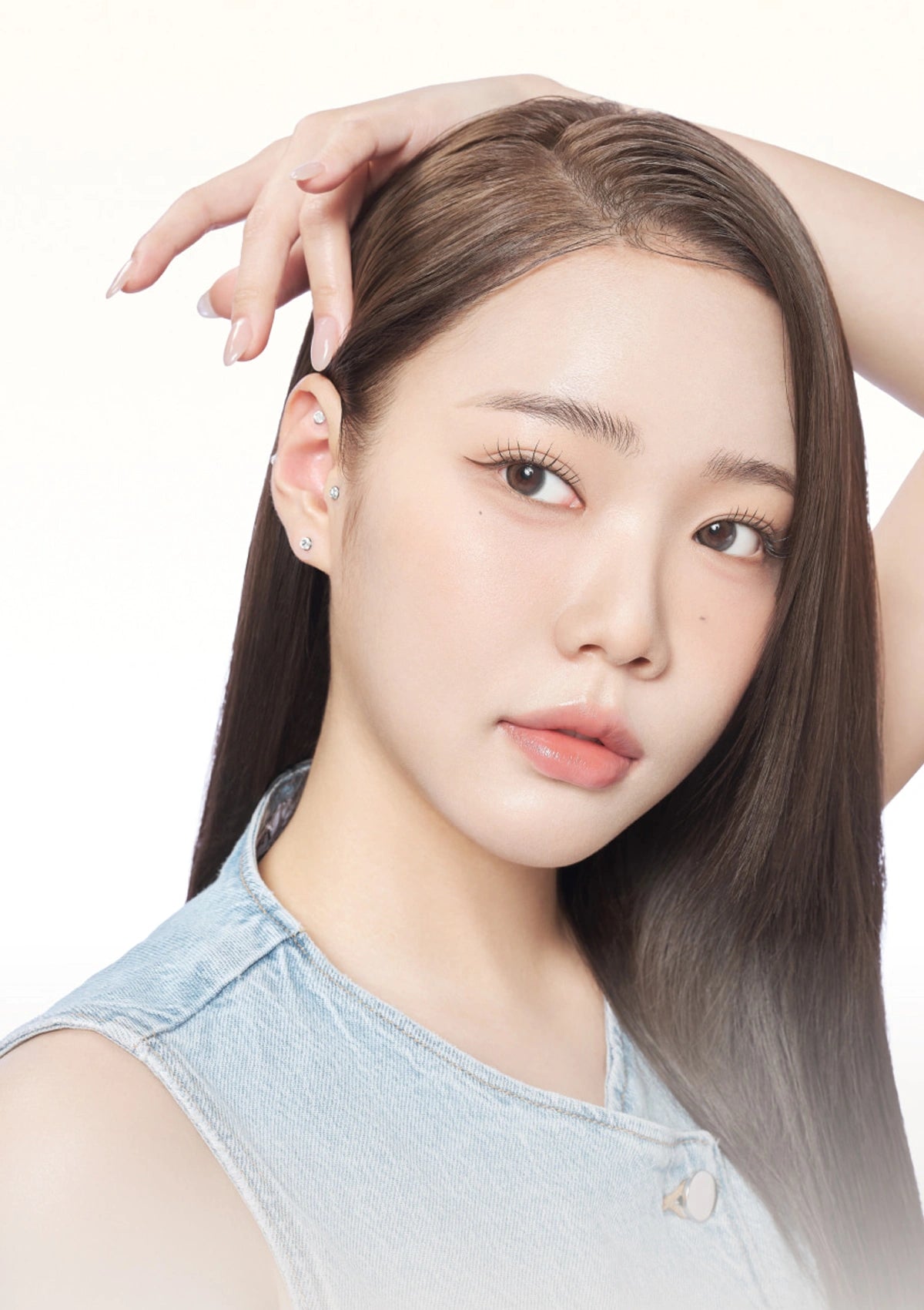 Woman with long hair and denim sleeveless top on a white background